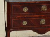a dresser with a mirror on top of it in front of a painting