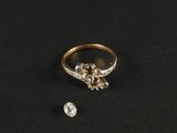 une bague en or et diamants, ornée de deux diamants sur un fond noir