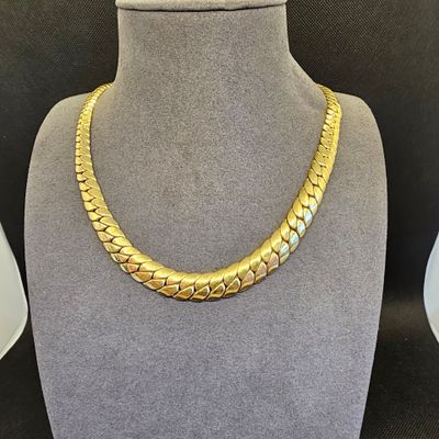 un collier à chaîne en or dans la vitrine d'un mannequin