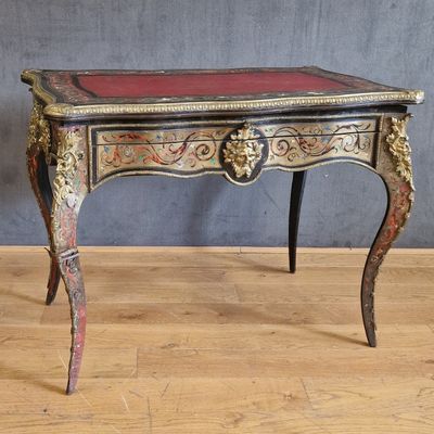 une petite table au plateau rouge posée sur un parquet