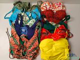 Plusieurs maillots de bain sont alignés sur une surface blanche