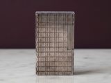 un petit objet métallique posé sur une surface en marbre