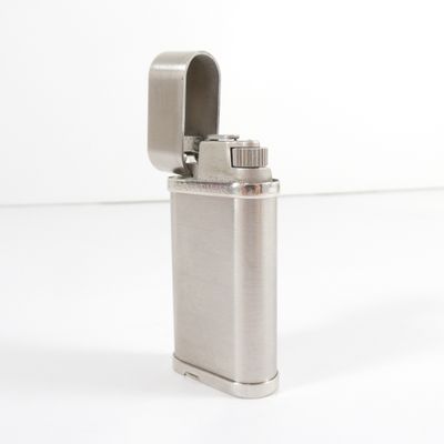 silver metal lighter on a white surface with a white background