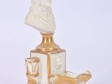 a statue of a man sitting on top of a table next to a vase
