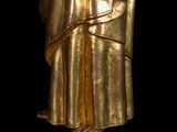 golden statue of a man with a hat and robe on a black background