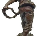 bronze statue of a man holding a baseball glove and a ball