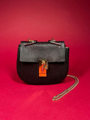 a black purse with a gold chain hanging from it