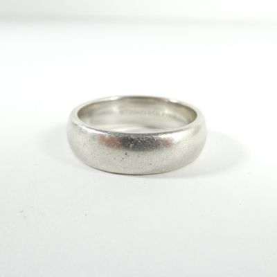 gros plan d'une bague en argent sur une surface blanche