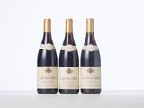 three bottles of wine are lined up on a table