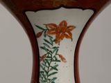 a vase that has a flower on it on a table