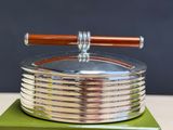 a silver plate with a wooden handle on top of a green box