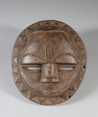 gros plan d'un masque en bois sur une surface blanche