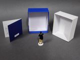 a small figurine of a man standing in front of a box