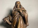 bronze statue of a man holding a book in his right hand