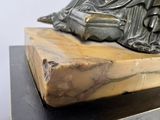 a statue of a buddha sitting on top of a wooden block