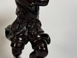 une statue représentant un garçon jouant de la trompette sur un rocher