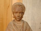 a small statue of a woman sitting on a table