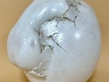 une boule blanche fêlée posée sur une table