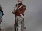 two figurines of men in uniforms of different sizes and colors