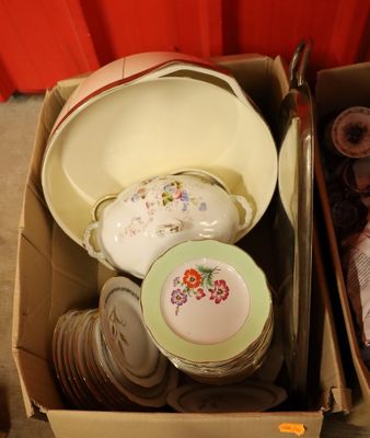 une boîte remplie d'assiettes et de bols posée par terre