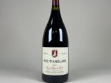 a bottle of red wine sitting on top of a white table