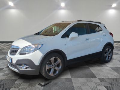 Le SUV Buick blanc est garé sur un sol en carrelage à damier.