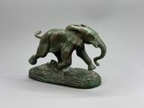 statue en bronze représentant un éléphant posé sur un rocher, sur fond blanc