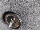 a button that is on the side of a gray jacket