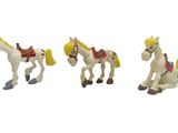 many small figurines of horses and dogs on a white surface