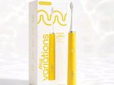 une brosse à dents jaune posée à côté d'un tube de dentifrice jaune