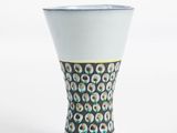 a white vase with a pattern on it on a white surface