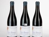 trois bouteilles de vin posées sur une table blanche