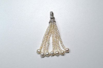 une photo d'un collier blanc orné de perles