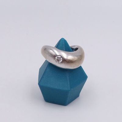 silver ring with a diamond on top of a blue cube