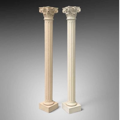 une paire de colonnes en marbre blanc, chacune ornée de chapiteaux sculptés