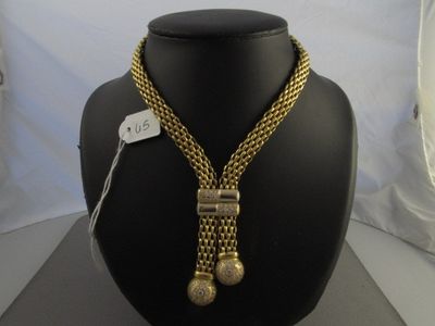 Ensemble collier et bracelet couleur or présenté sur un mannequin d'exposition