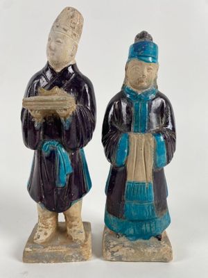 paire de figurines en céramique représentant un homme et une femme tenant un livre