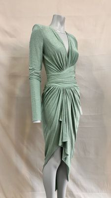 the mannequin is wearing a green dress on a white mannequin