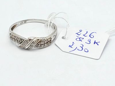 une bague en argent sertie de diamants, à côté d'une étiquette de prix