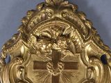 a gold clock with a cross on the front of it