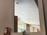 a fireplace with a mirror above it and a vase on top of it
