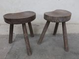 two wooden stools that are sitting next to each other