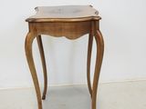 a small wooden table with a marble top on it