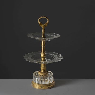 a three tiered glass cake stand with a gold handle