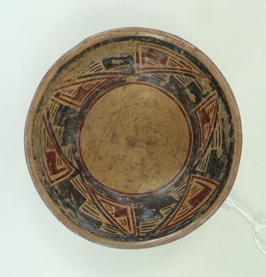 une image représentant un bol marron orné de motifs sur un fond blanc