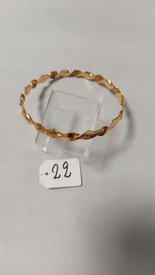 gros plan d'un bracelet en or portant une étiquette de prix