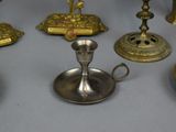 many different types of brass candles on the table