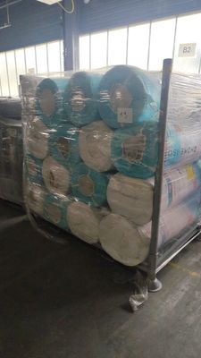 de nombreux rouleaux de papier toilette posés sur un chariot dans un entrepôt