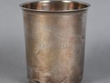 a close up of a silver cup on a gray surface