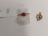 a ring and a ring with a red stone on top of it